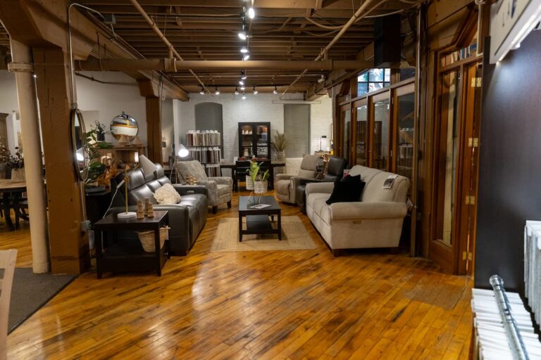 Modern furniture showroom with sofas and wooden floors.